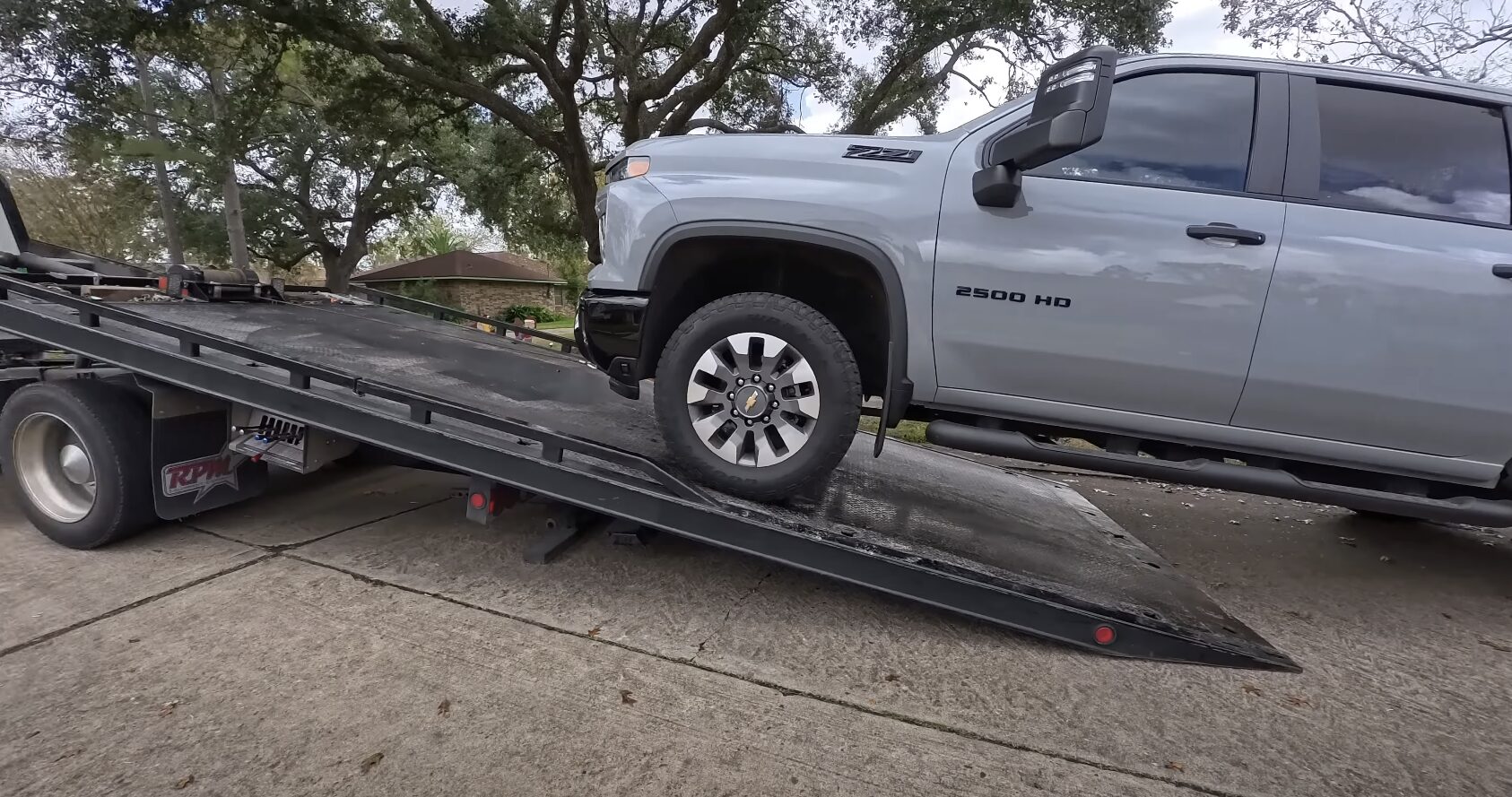 Heavy-duty towing service loading large pickup truck on flatbed