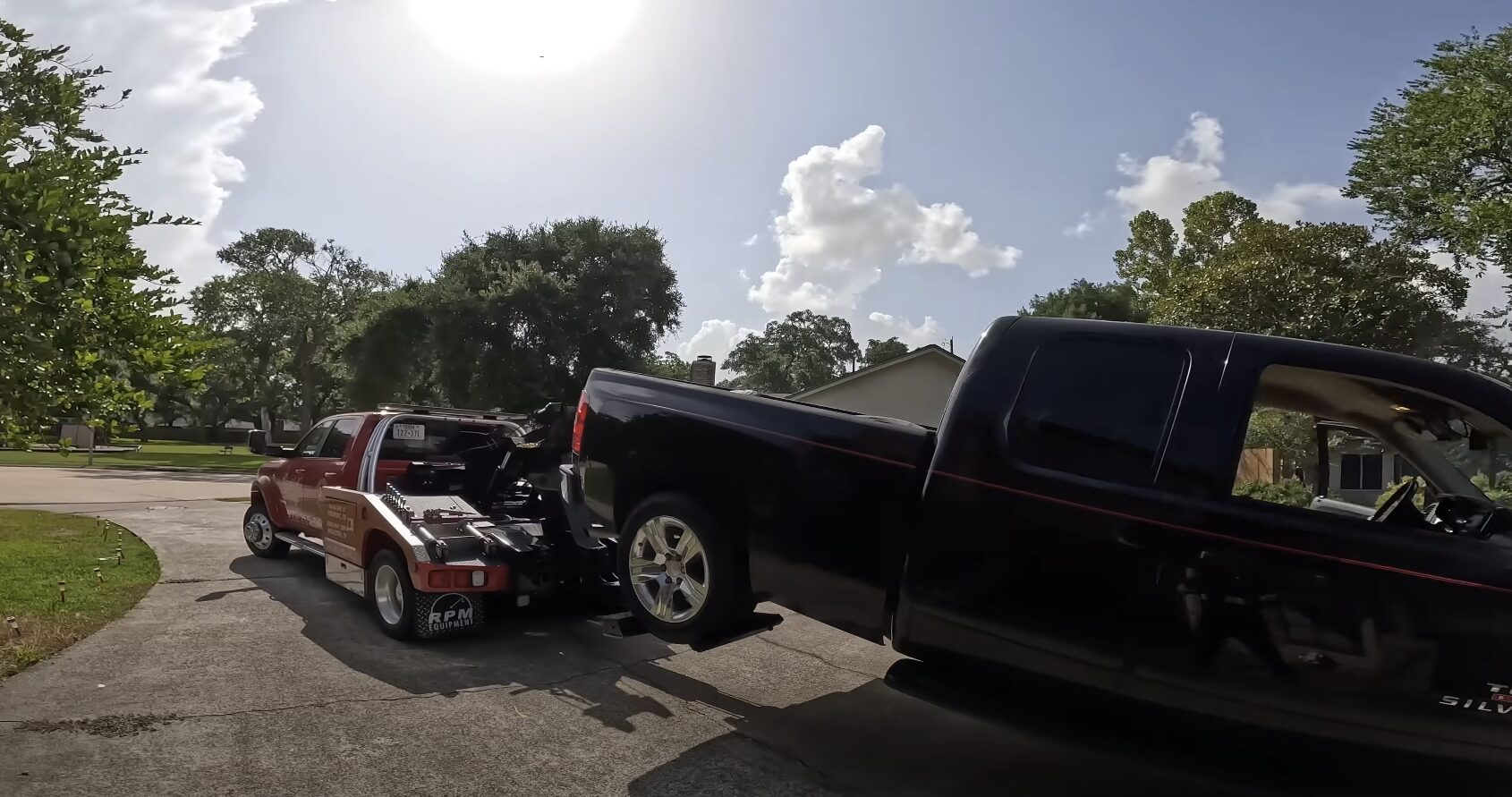 Tow truck operator loading vehicle with professional equipment